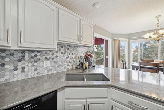 kitchen with a sink, white cabinetry, decorative backsplash, dishwasher, and a chandelier