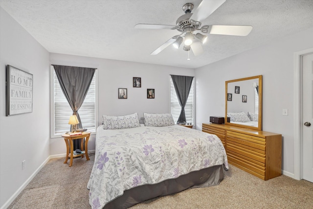 bedroom with baseboards, light carpet, a textured ceiling, and ceiling fan