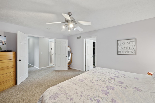 carpeted bedroom featuring visible vents, ceiling fan, a textured ceiling, and baseboards