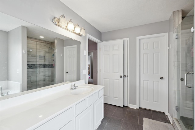 bathroom with baseboards, a garden tub, a stall shower, and vanity