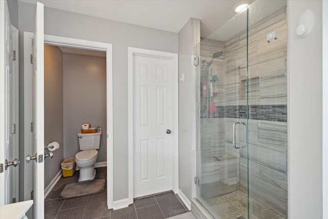 full bathroom with a shower stall, toilet, and baseboards