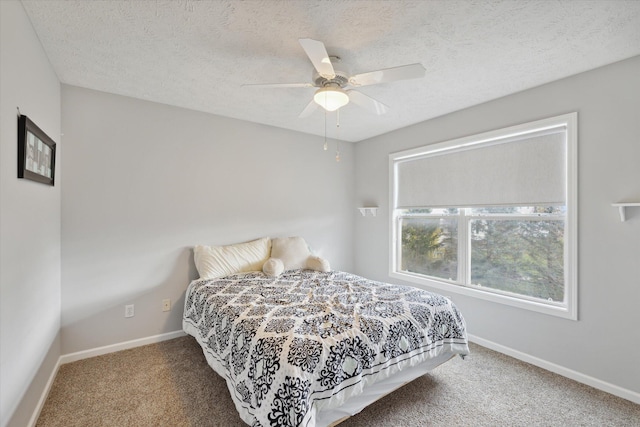 carpeted bedroom featuring ceiling fan, baseboards, and a textured ceiling