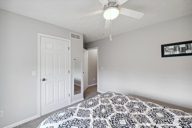 carpeted bedroom featuring visible vents, baseboards, a textured ceiling, and ceiling fan