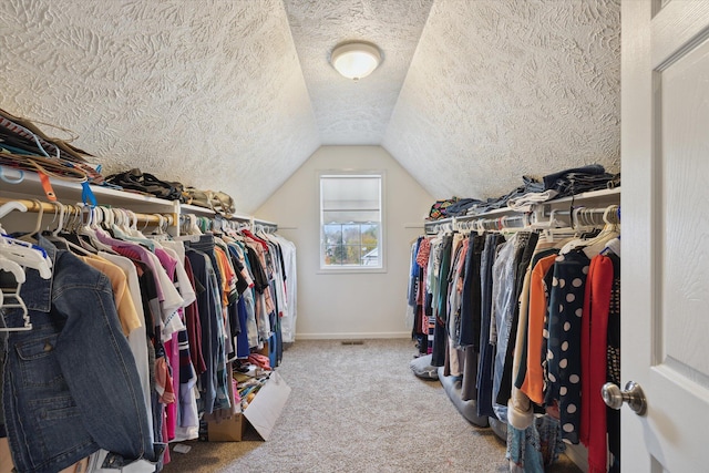 walk in closet with lofted ceiling and carpet flooring