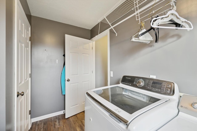 laundry area featuring washer and dryer, laundry area, baseboards, and dark wood-style flooring