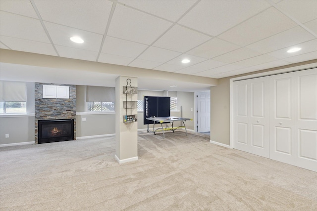 below grade area with baseboards, a drop ceiling, carpet flooring, recessed lighting, and a fireplace