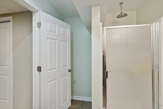 bathroom with tile patterned flooring, a shower stall, and baseboards