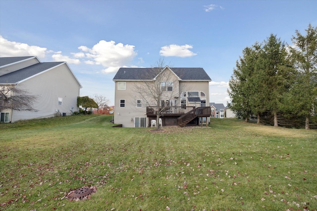 rear view of house featuring stairway, a lawn, and a wooden deck