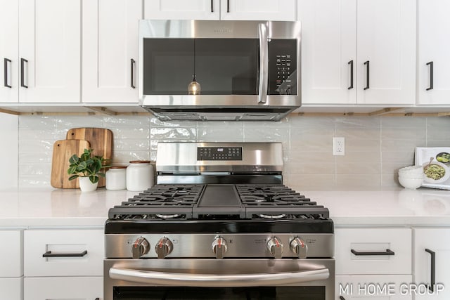 kitchen with stainless steel appliances, tasteful backsplash, and white cabinetry