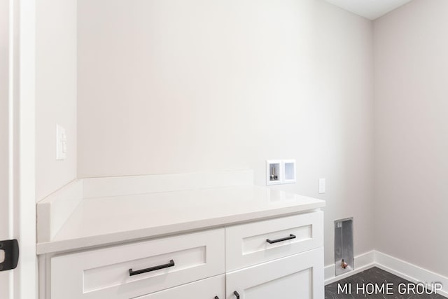 laundry room with cabinet space, baseboards, and washer hookup