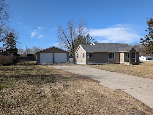 ranch-style house featuring a front yard, fence, roof with shingles, an outdoor structure, and a detached garage