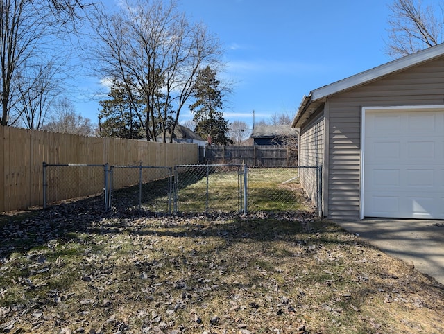 view of yard featuring an outbuilding, a garage, and a fenced backyard