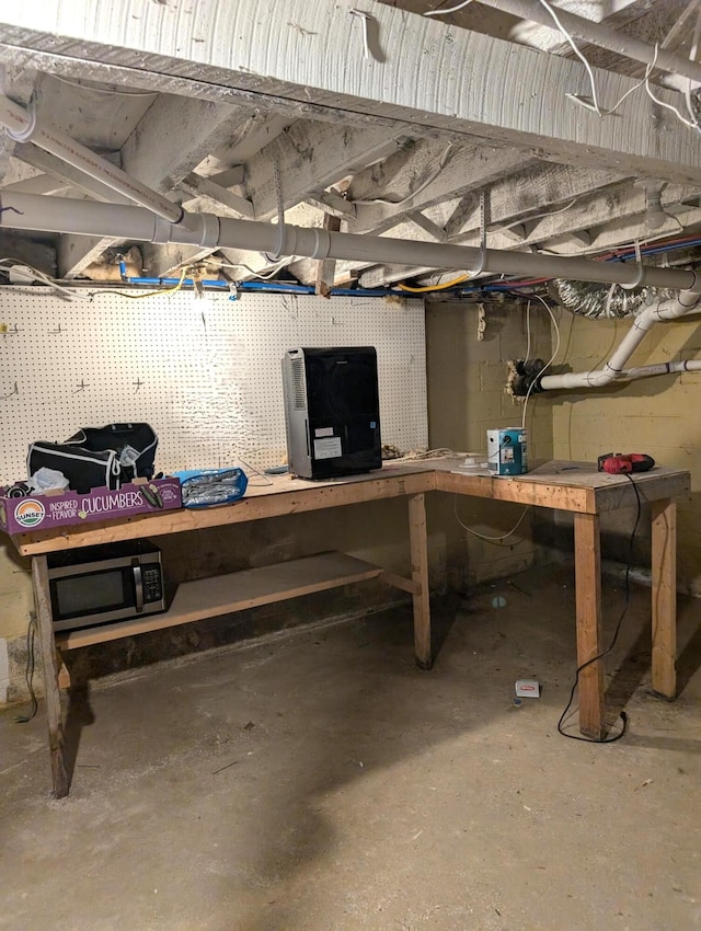 unfinished basement featuring a workshop area