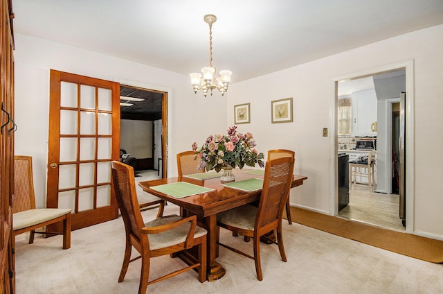 dining area featuring light colored carpet and an inviting chandelier