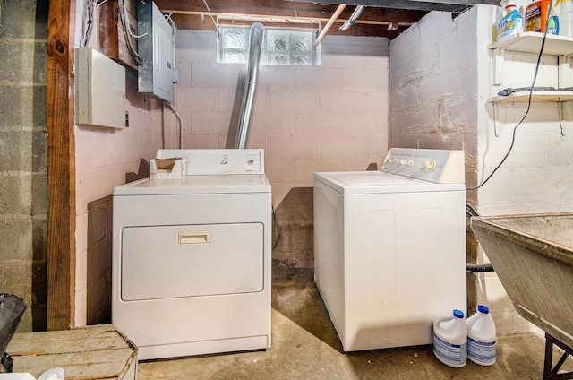 laundry room featuring electric panel, washing machine and dryer, laundry area, and a sink