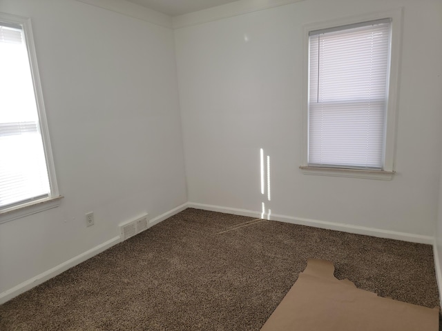 unfurnished room with baseboards, visible vents, and carpet floors