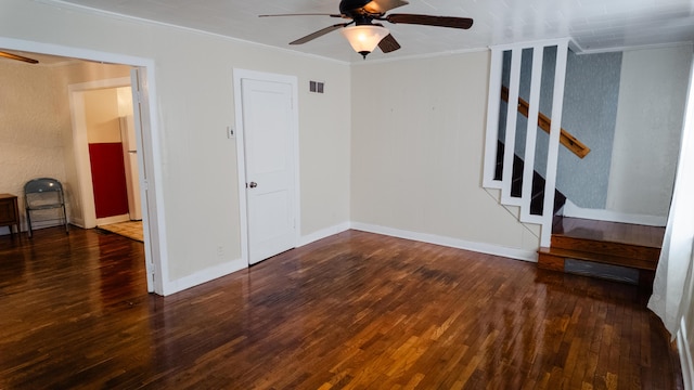 empty room with wood finished floors, visible vents, a ceiling fan, stairs, and crown molding