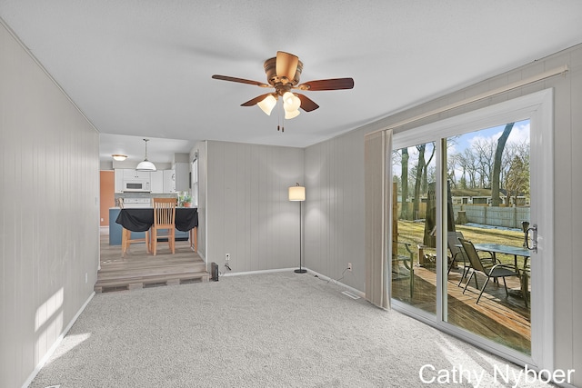 spare room with baseboards, light colored carpet, and ceiling fan