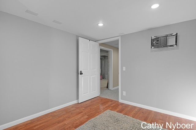 unfurnished room featuring recessed lighting, baseboards, and wood finished floors