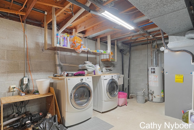 washroom featuring gas water heater, heating unit, independent washer and dryer, and laundry area