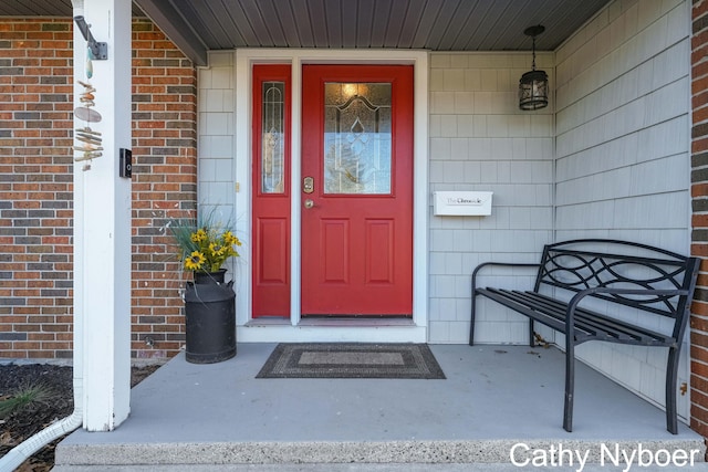 property entrance with brick siding and covered porch