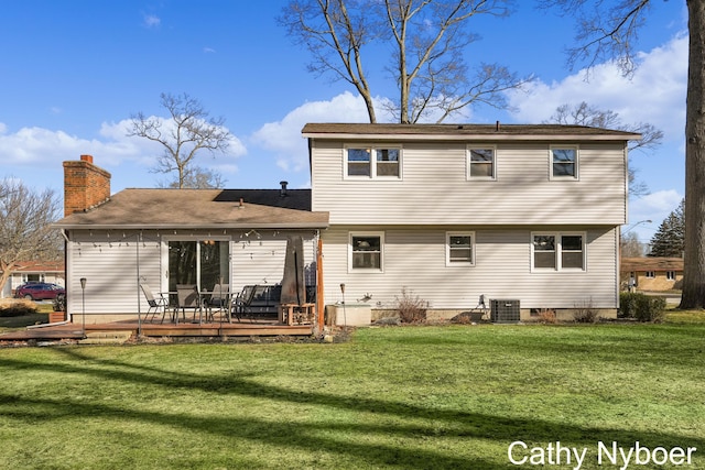 back of house with a wooden deck, a lawn, and a chimney