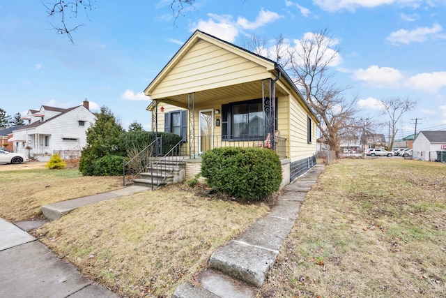 view of front of property with a front lawn, covered porch, and a residential view