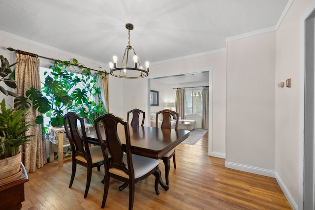 dining room featuring a notable chandelier, baseboards, light wood-style floors, and crown molding