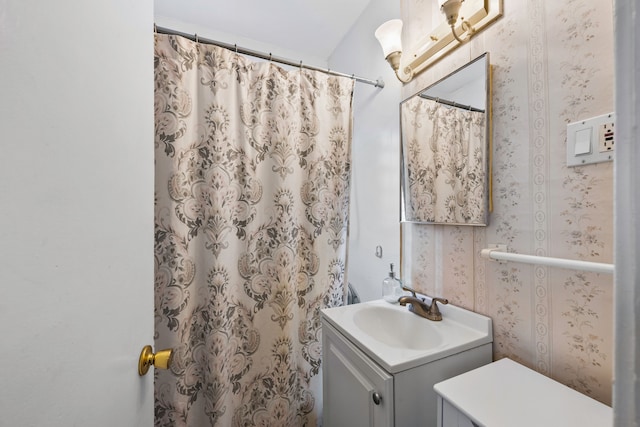 full bathroom with curtained shower, vanity, and wallpapered walls