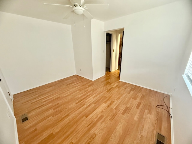 empty room featuring visible vents, baseboards, light wood-style floors, and ceiling fan