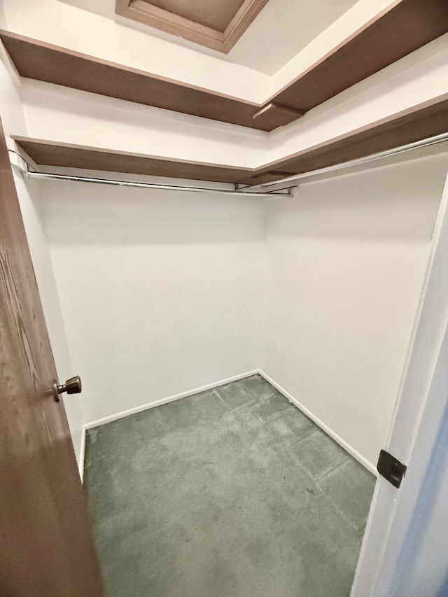 walk in closet featuring dark colored carpet