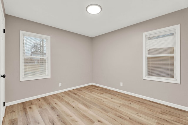 spare room with light wood-type flooring and baseboards