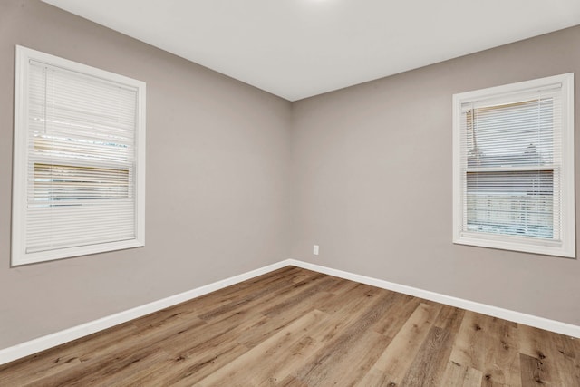 unfurnished room with baseboards and wood finished floors