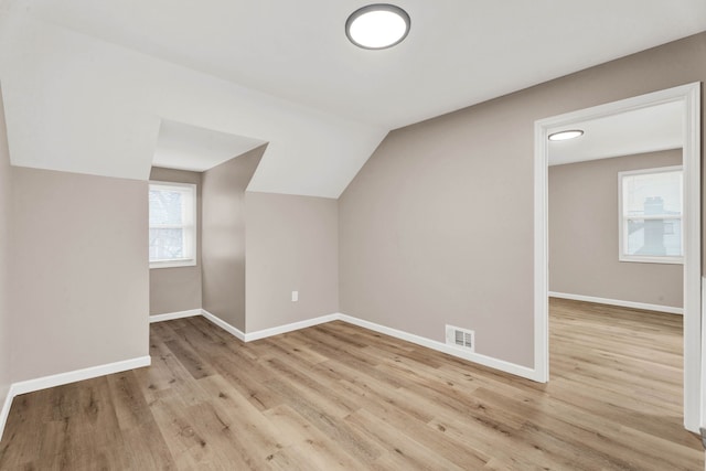 bonus room with light wood-style flooring, baseboards, and visible vents