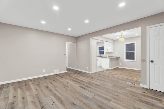 unfurnished living room featuring recessed lighting, visible vents, baseboards, and light wood-style flooring