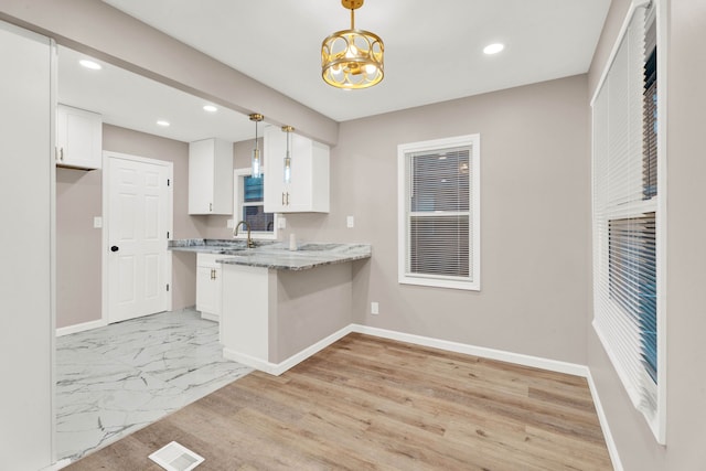 kitchen featuring white cabinets, baseboards, and visible vents