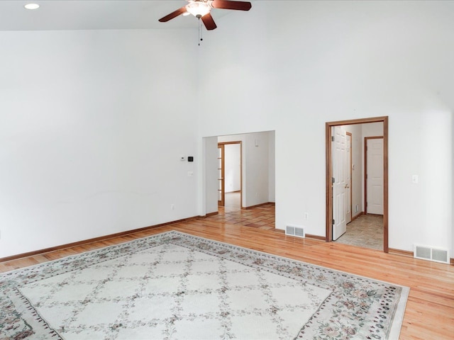 unfurnished room with visible vents, a high ceiling, and light wood-style flooring