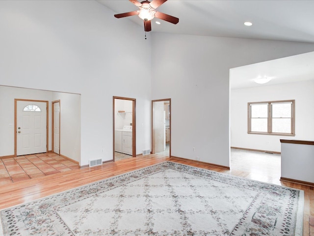 unfurnished living room with light wood finished floors, visible vents, recessed lighting, and high vaulted ceiling