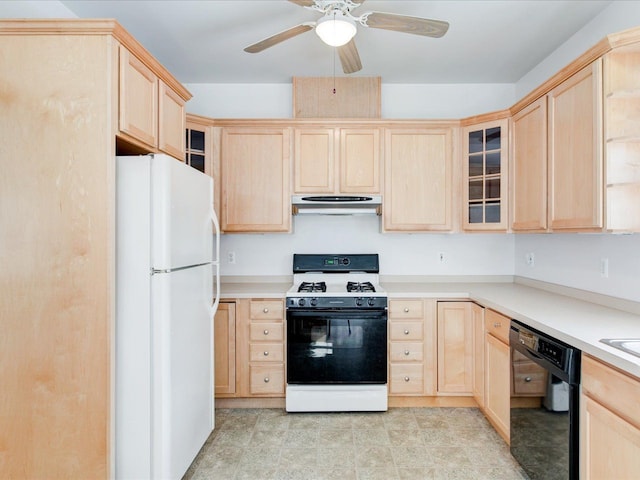 kitchen with light brown cabinets, under cabinet range hood, range with gas stovetop, black dishwasher, and freestanding refrigerator