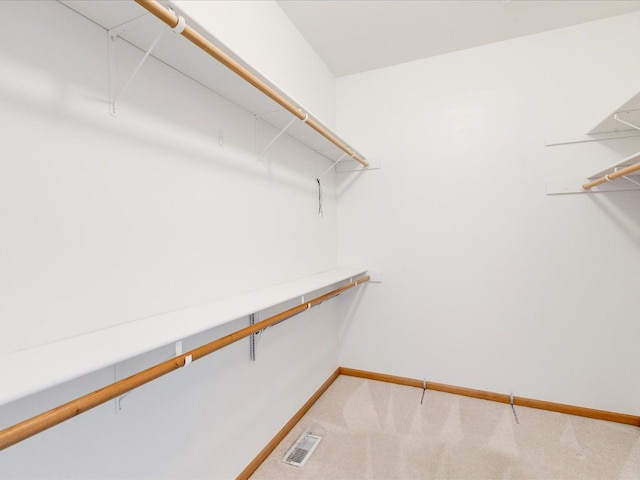 spacious closet with visible vents and light colored carpet