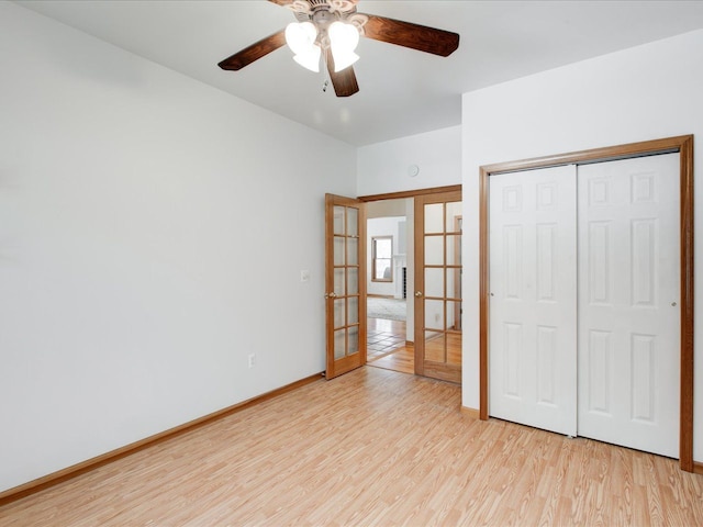 unfurnished bedroom featuring french doors, light wood-style floors, a closet, and baseboards