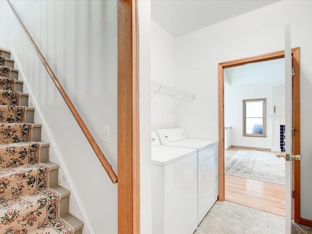 clothes washing area featuring washer and clothes dryer, laundry area, and baseboards