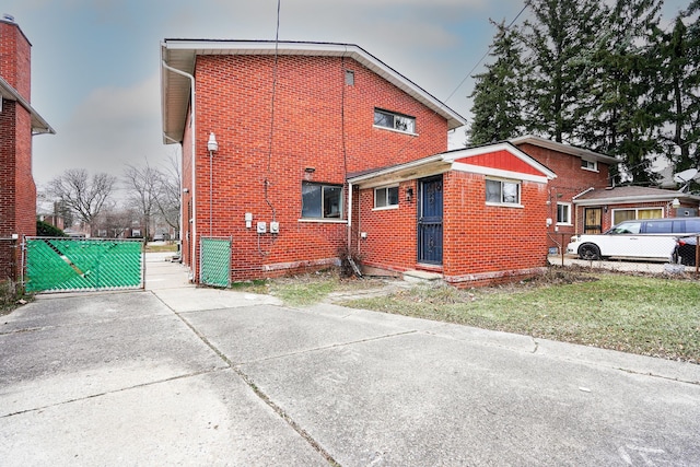 view of home's exterior featuring a gate, fence, and brick siding