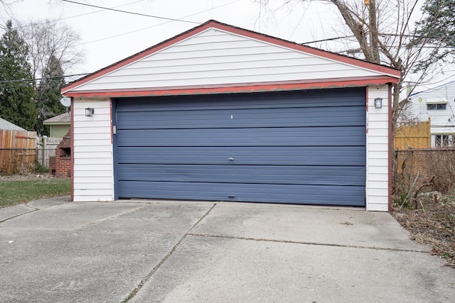 detached garage featuring fence