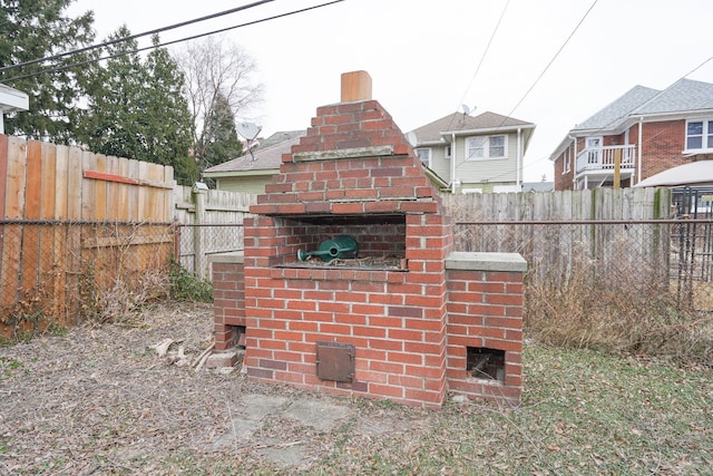 exterior space with a fenced backyard and a fireplace