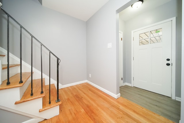 foyer featuring stairway, baseboards, and wood finished floors