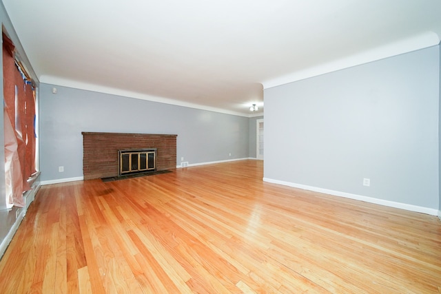 unfurnished living room with a fireplace, light wood-type flooring, and baseboards