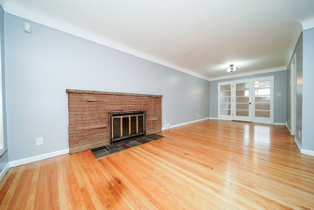 unfurnished living room featuring baseboards, wood finished floors, and a fireplace