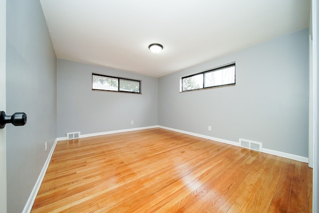 spare room with visible vents, plenty of natural light, and light wood-style flooring