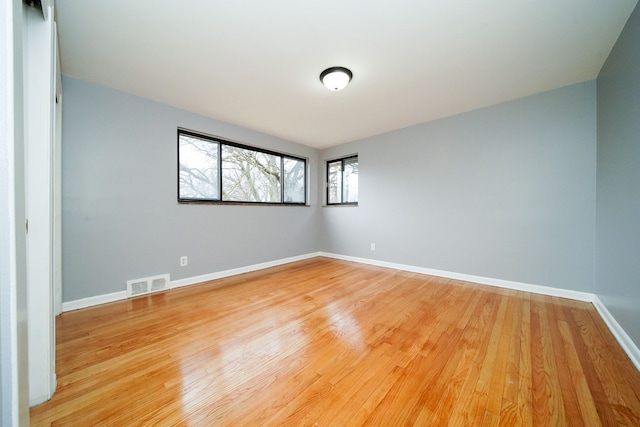 spare room with visible vents, baseboards, and light wood-style flooring